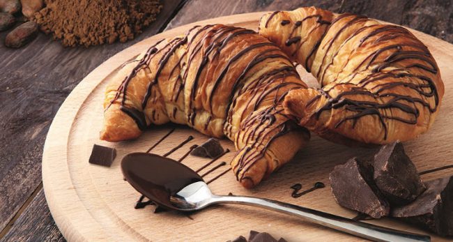 Fresh homemade croissants with chocolate. Sweet bakery concept.